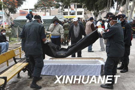 救援人员在秘鲁地震重灾区皮斯科市将死难者遗体装入棺材