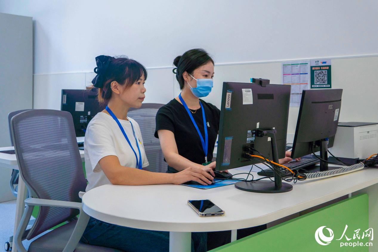 梅丽丽（左）和同事正在查看转诊信息。人民网 林铭贤摄
