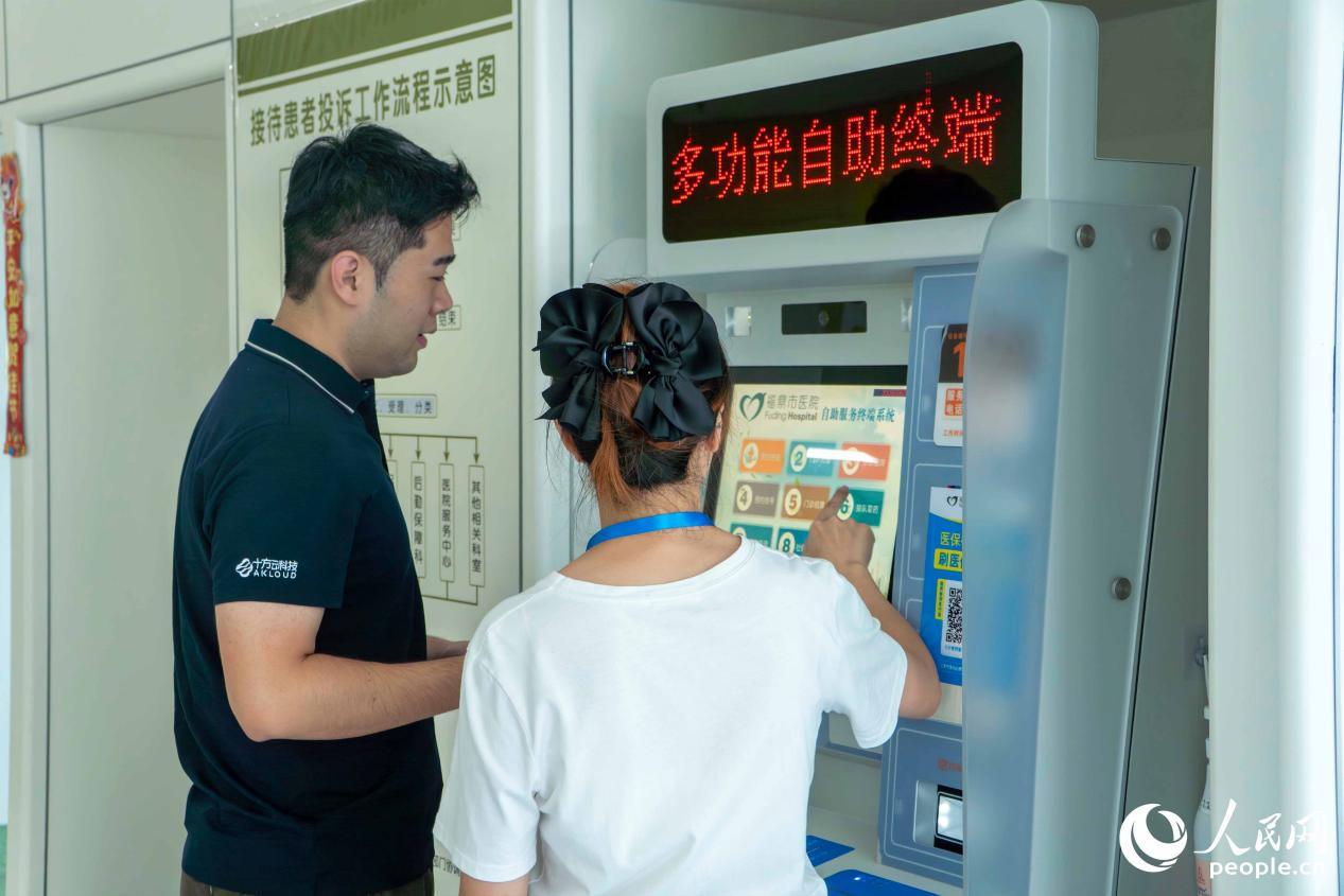 梅丽丽正在协助患者家属挂号。人民网 林铭贤摄