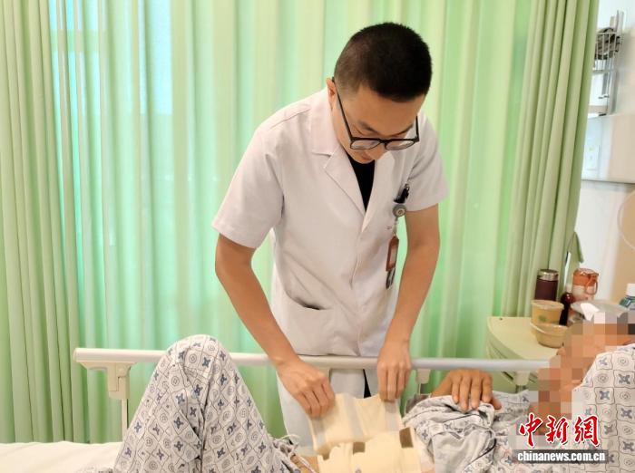 急诊普外科医生肖琨在病房内为患者查体。受访者供图
