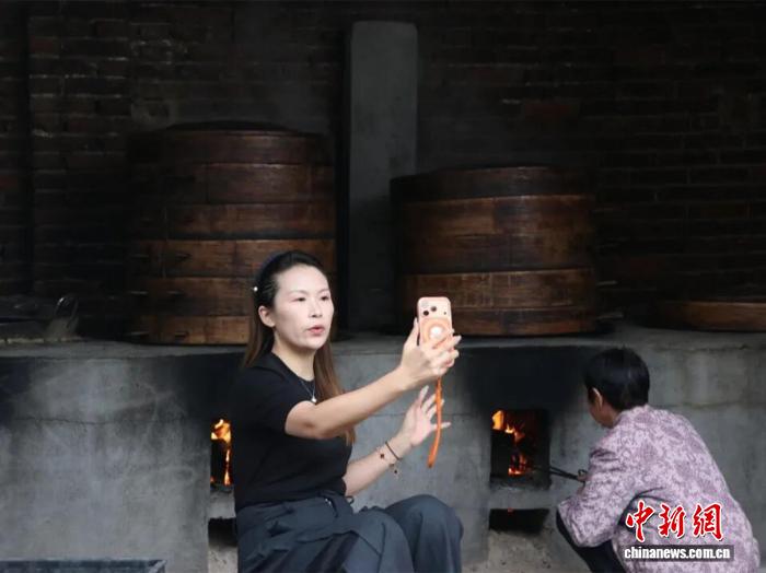 廉桥镇青年唐媛对着手机镜头录制中医药科普短视频。　邵东市委宣传部 供图